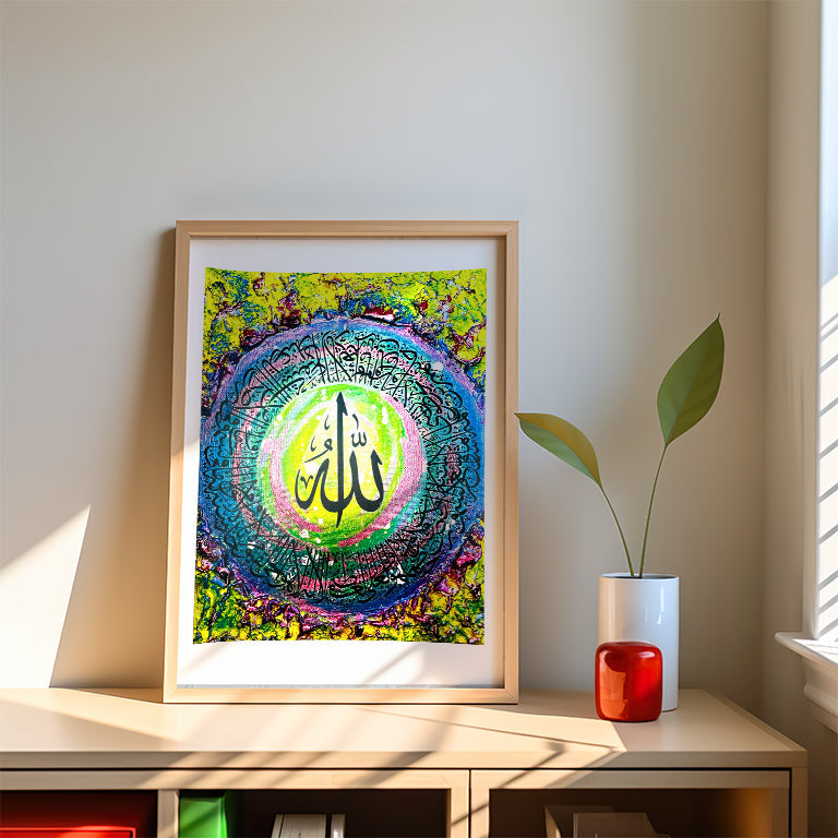 Framed colorful artwork on a shelf with a plant and small red object.