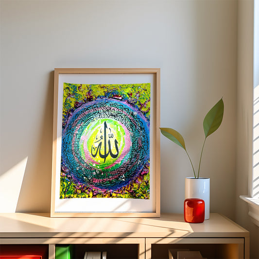 Framed colorful artwork on a shelf with a plant and small red object.